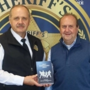 Oconee County Sheriff Mike Crenshaw and Joey Hudson pose together with a First Responder Bible. Photo by Caleb Gilbert