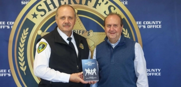 Oconee County Sheriff Mike Crenshaw and Joey Hudson pose together with a First Responder Bible. Photo by Caleb Gilbert